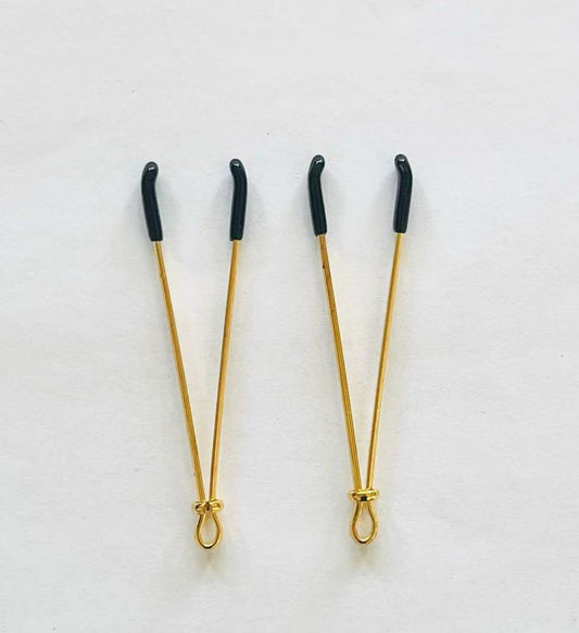 Gold adjustable wire-style nipple clamps with black rubber tips, minimalist BDSM design