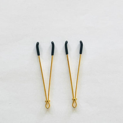 Gold adjustable wire-style nipple clamps with black rubber tips, minimalist BDSM design