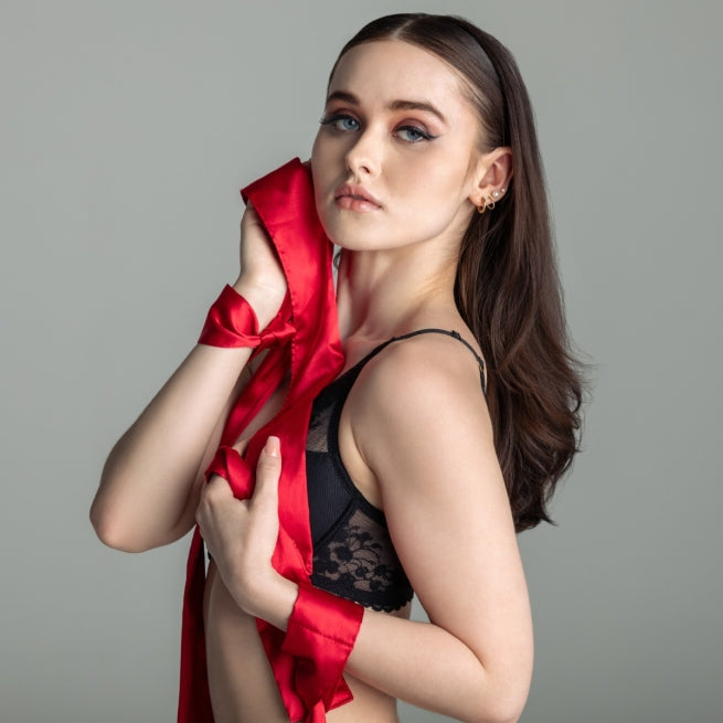 Woman holding a red fabric against a gray background